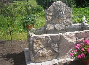 Une fontaine en béton habillée de pierres de pays